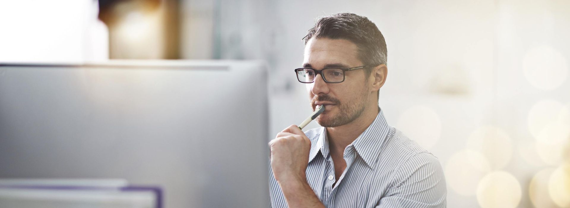 Man looks thoughtfully at a screen on a table